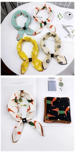 Detail of assorted printed silk scarves featuring animal patterns and black slider buckles