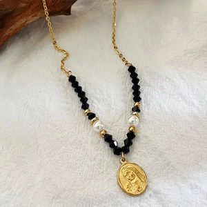 Collana retrò con perline nere e perle e ciondolo Maria dorato su lino bianco