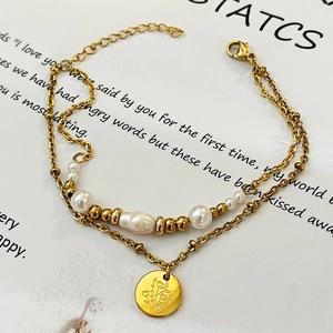 Bracelet double rang en acier doré avec perles, billes et pendentif fleur gravé
