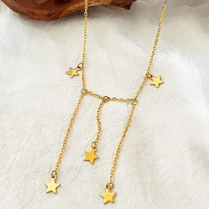 Elegant gold stainless steel necklace with five star charms on white fabric background