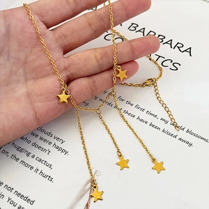 Elegant gold stainless steel star tassel necklace with five star pendants held by hand