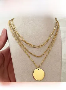 Detailed close-up of a three-layer gold stainless steel necklace with a round pendant