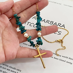 Collier croix dorée avec éclats de turquoise et perles blanches sur chaîne fine