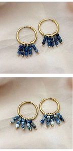 Détail de créoles plaquées or 18k avec pompons en perles de pierre naturelle bleue