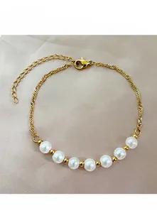 Détail du bracelet chaîne dorée avec six perles blanches et fermoir mousqueton réglable