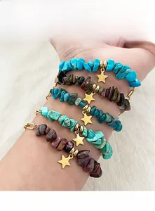 Détail des bracelets en perles de pierre naturelle avec pendentifs étoile dorée au poignet