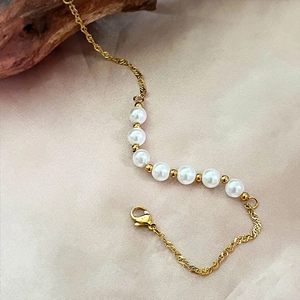 Bracelet élégant à chaîne dorée torsadée avec sept perles blanches et fermoir mousqueton