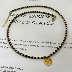 Collier fait main en perles noires avec pendentif floral doré et chaîne réglable