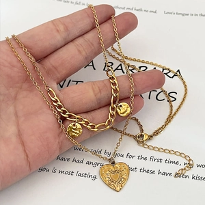 Gold layered heart pendant necklace with Cuban chain and sunburst textured medal charms