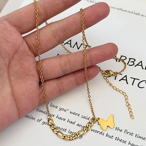 Goldene Schmetterlingshalskette mit Gliederkette zur Größenansicht in der Hand gehalten