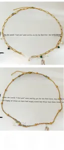 Détail de colliers dorés superposés avec perles de malachite et chaîne trombone élégante