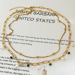 Collier double rang doré avec perles et pendentif malachite verte sur papier d'art