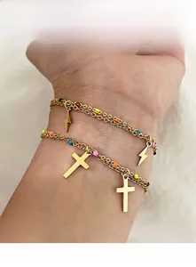 Detail of gold titanium steel chain bracelet with colorful enamel beads and cross charms