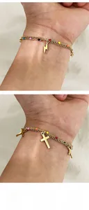 Detail of gold layered chains with cross charms and lightning bolt pendant with color beads
