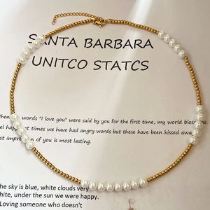 French pearl necklace with gold beads and heart charm on minimal white background