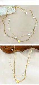 Gros plan sur un collier double rang doré orné de perles blanches et d'un cœur