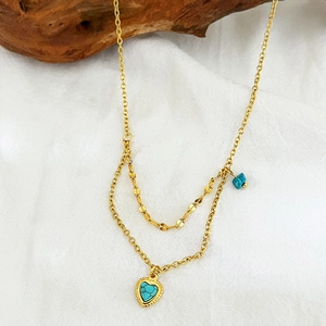 Vintage layered 18K gold-plated necklace with turquoise heart pendant on wood surface