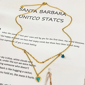 Double layer gold necklace with blue triangle charm and turquoise heart pendant