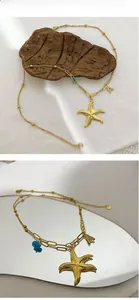 Détail du collier étoile de mer doré avec perle bleue et breloque lettre A