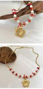 Detail of gold flower pendant with pearl and red gravel beads on stainless steel chain