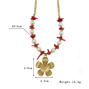 Handmade beaded necklace with white pearls, red stones, and a gold flower pendant
