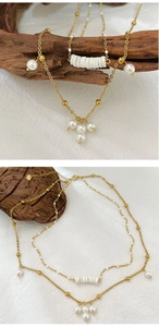 Detail of gold double-layer necklace featuring white pearl pendants and cylinder bead