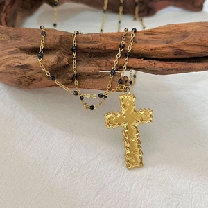 Collana doppia croce in oro 18k con perline nere su espositore in legno rustico chic