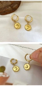 Detailed view of 18K gold plated hoop earrings with crescent moon relief and vintage texture