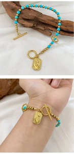 Detail of beaded bracelet with turquoise stones and a gold engraved pendant with OT clasp