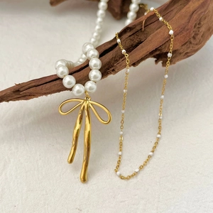 Collier de perles élégant avec pendentif nœud doré sur bois, accessoire bijoux raffiné