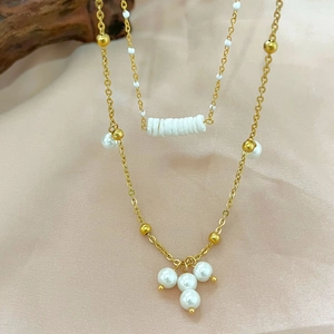 Elegant double-layered stainless steel necklace with white pearls on soft pink silk