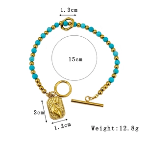 Bohemian beaded bracelet with blue stones, gold beads, and palm pendant on white background
