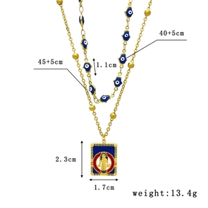 Double-layered gold necklace featuring Evil Eye charms and religious pendant on white background