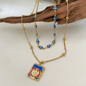 Vintage gold square pendant necklace with religious icon and evil eye charms on wood