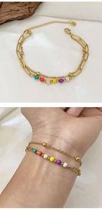 Detail of double-layer gold chain bracelet with colorful beads and adjustable clasp