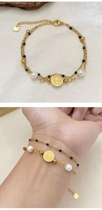Detail of double-layer stainless steel bracelet with pearls and Virgin Mary medal