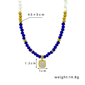 Beaded necklace with blue stones, pearls and a square rhinestone pendant on white background