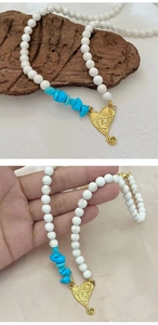 Detail of bohemian seed bead necklace featuring turquoise accents and heart landscape pendant
