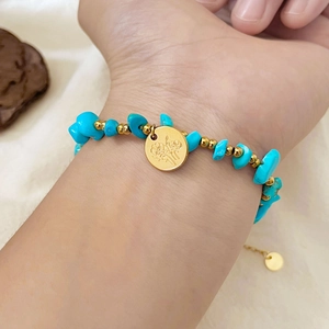 Böhmisches Goldblumen-Armband mit unregelmäßigen Türkissteinen an einem Frauenhandgelenk