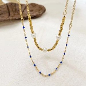 Double-layered gold titanium steel necklace with white pearls and blue beads accents
