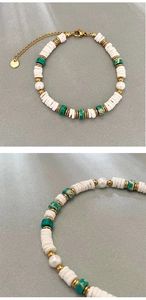 Detail of beaded bracelet with green marble stones, white discs and S.steel chain
