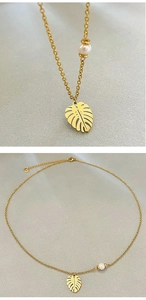 Détail du collier pendentif feuille de monstera dorée avec une perle blanche unique