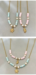 Détail de pendentifs étoile de mer et coquillage en or 18k avec perles bleues