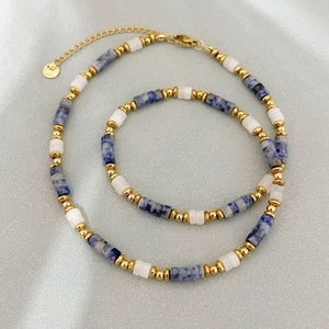 Collier artisanal avec perles de sodalite bleue, cylindres blancs et accents dorés