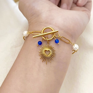 18K gold plated paperclip bracelet with heart sun charm, pearls and blue beads on wrist