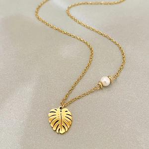 Collier en or 18 carats avec pendentif feuille de monstera et détail perle blanche
