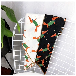 Detailed view of printed square scarves featuring cute orange fox patterns with rolled edges