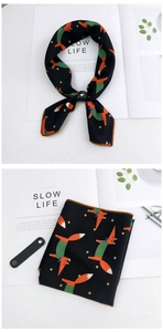 Detail of fox print silk scarf with a black leather slide buckle on minimal background