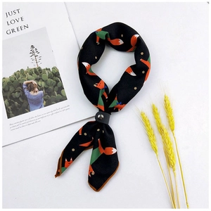Detail of black silk scarf with orange fox pattern and grey leather rivet fastener
