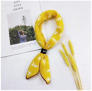 Detail of yellow cotton linen scarf with animal print and black leather buckle clasp